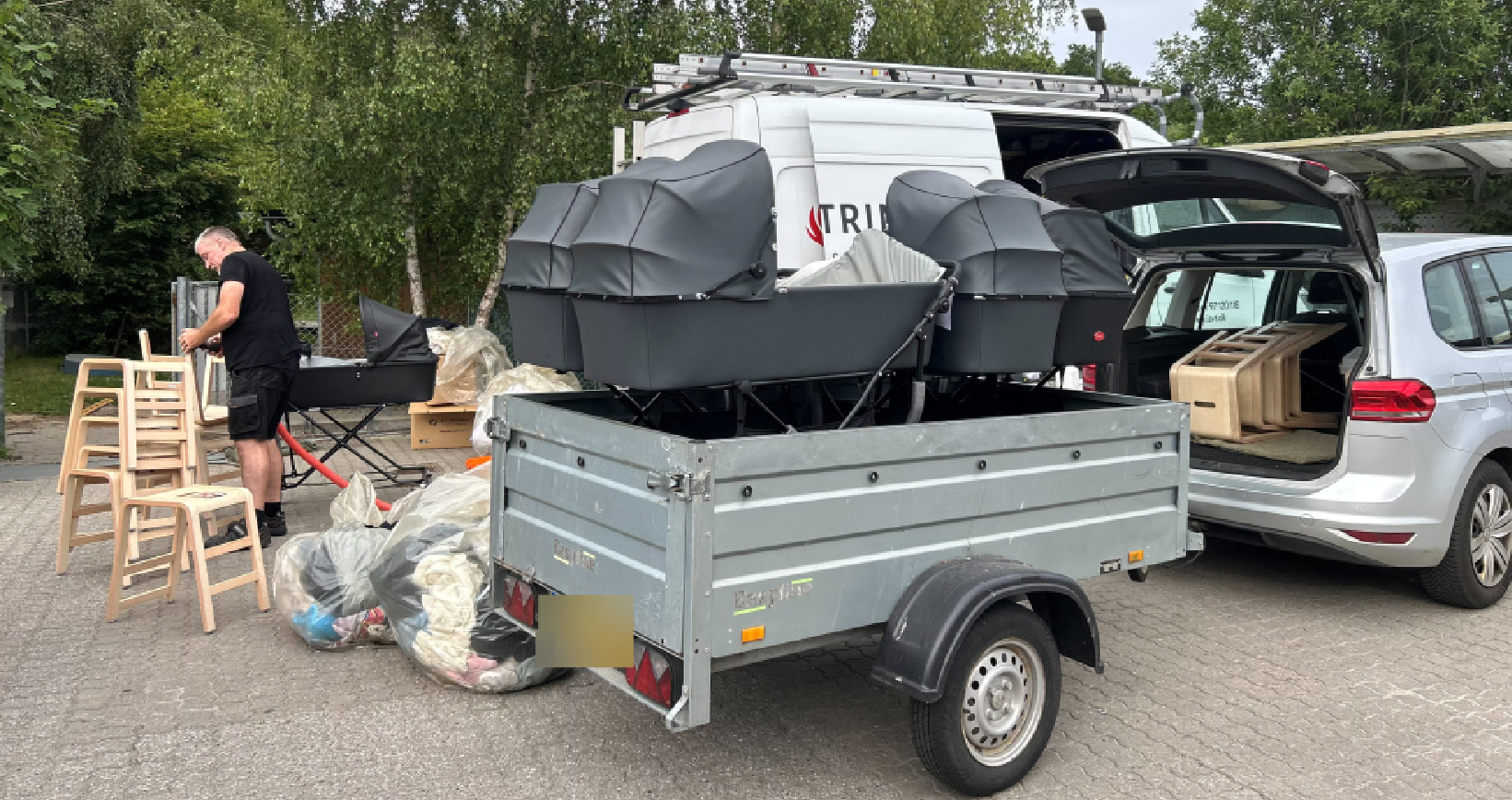 Barnevogne, stole og inventar pakkes på trailer og i biler uden for Børnehuset Guldsmeden i Skovby